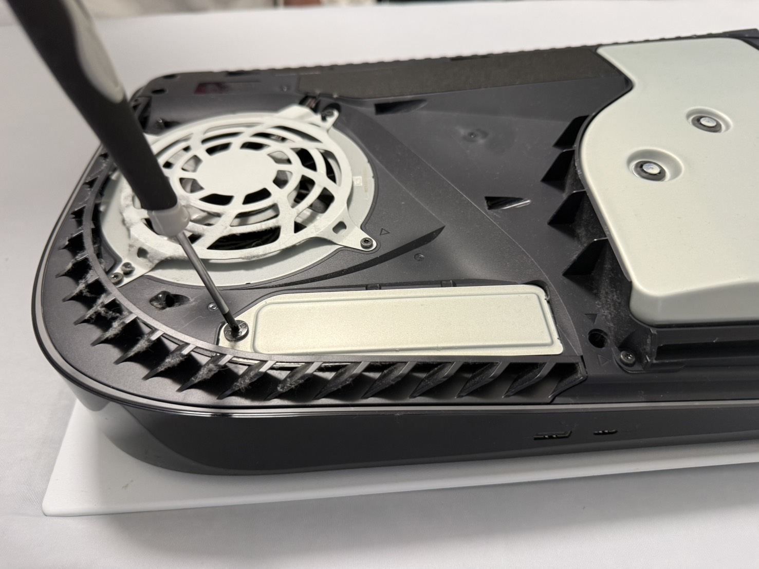 PS5のM.2 SSDスロットカバーを外している様子